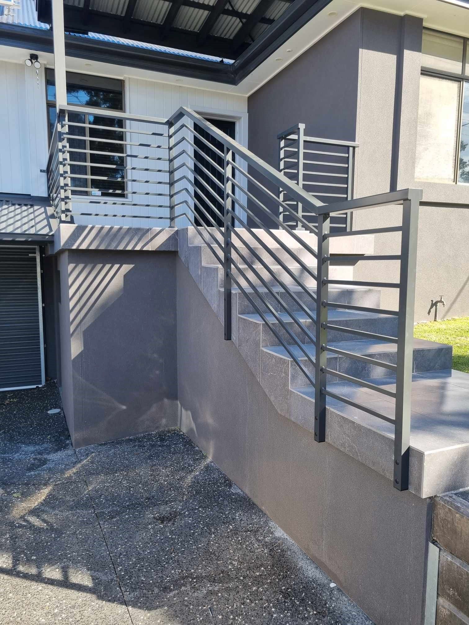 A Set of Stairs Leading Up to a Building With a Metal Railing — D & T Balustrade Systems In Unanderra, NSW