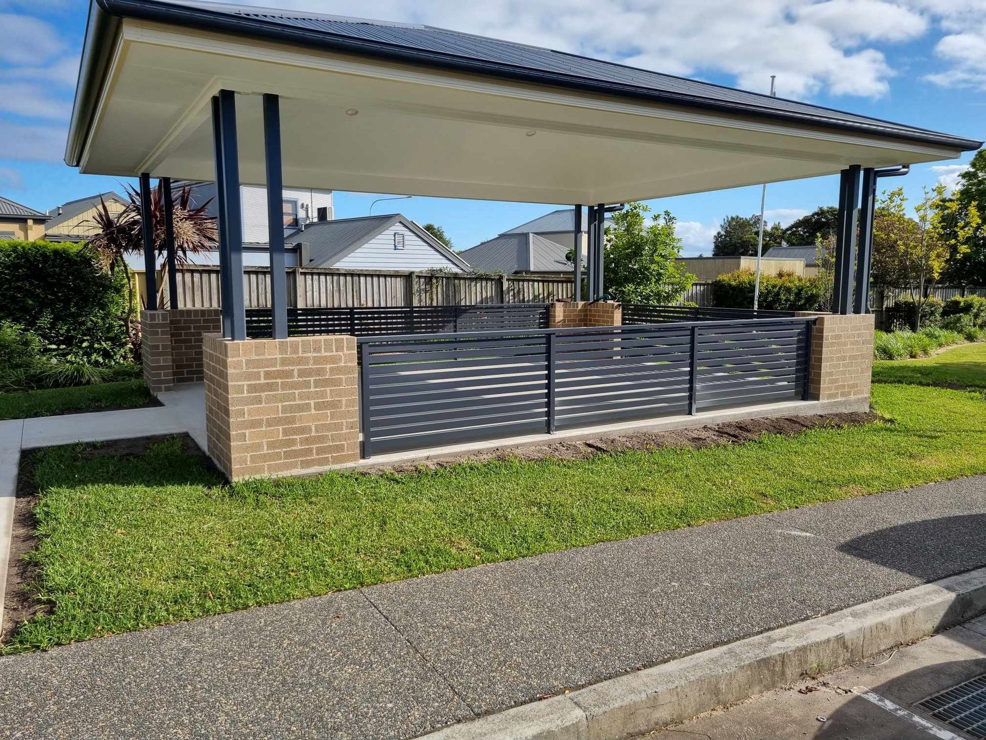 Covered outdoor seating area with brick columns and grey slatted fence — D & T Balustrade Systems In Unanderra, NSW