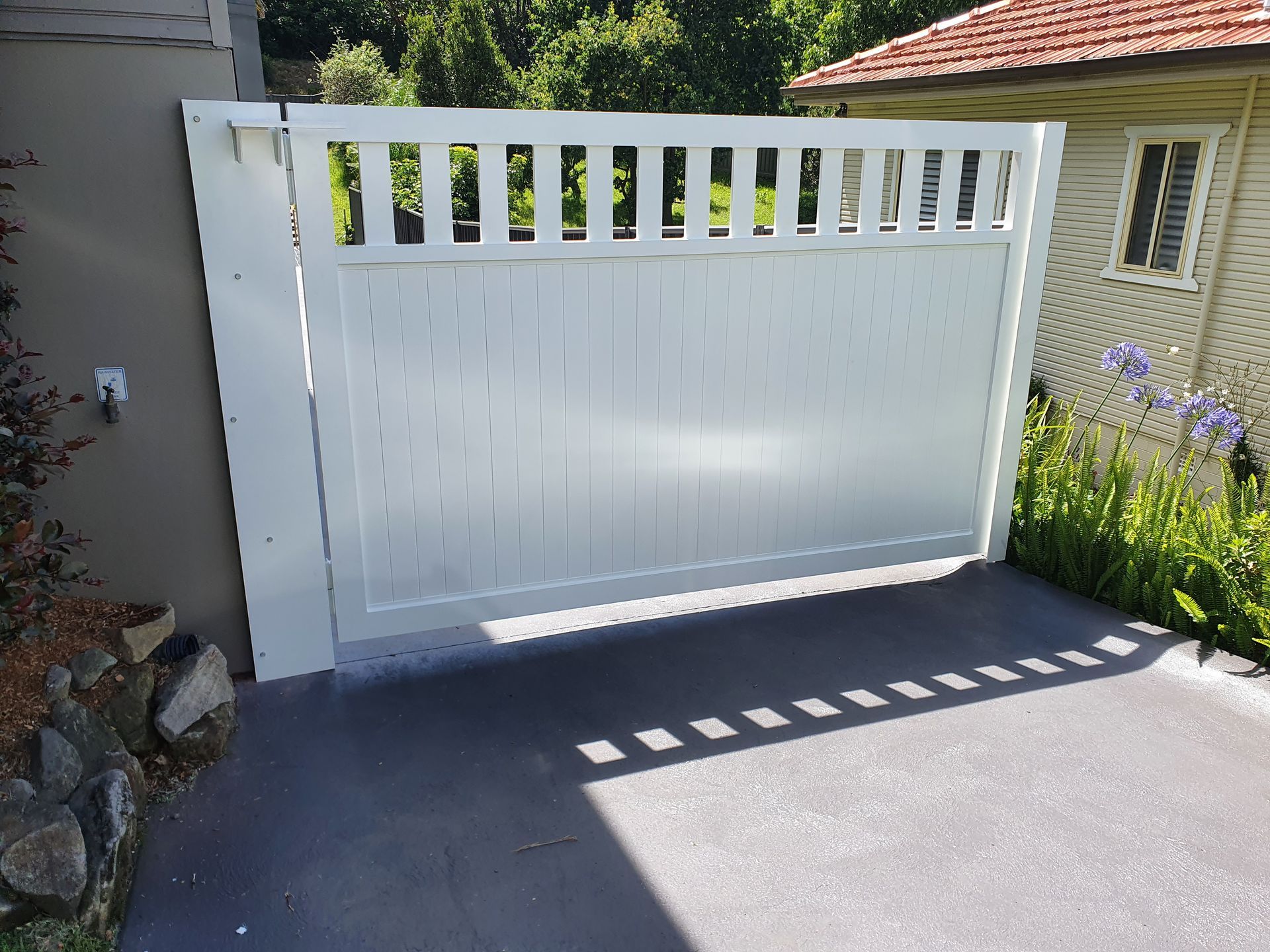 White automated gate beside a house — D & T Balustrade Systems In Unanderra, NSW
