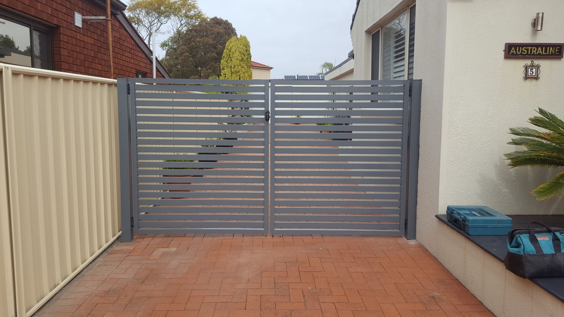 A Large House With a Sliding Gate in Front of It — D & T Balustrade Systems In Unanderra, NSW