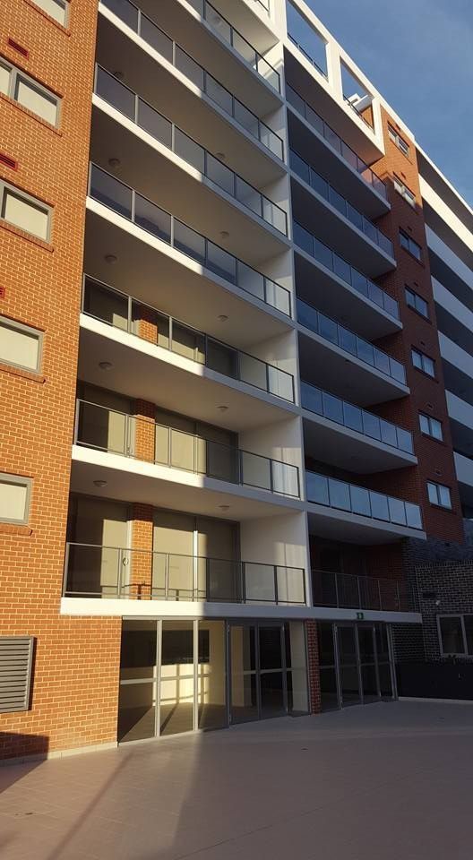 A Large Apartment Building With a Lot of Balconies — D & T Balustrade Systems In Unanderra, NSW