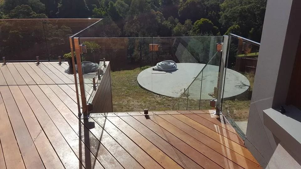 A Wooden Deck With a Glass Railing and Stairs — D & T Balustrade Systems In Unanderra, NSW