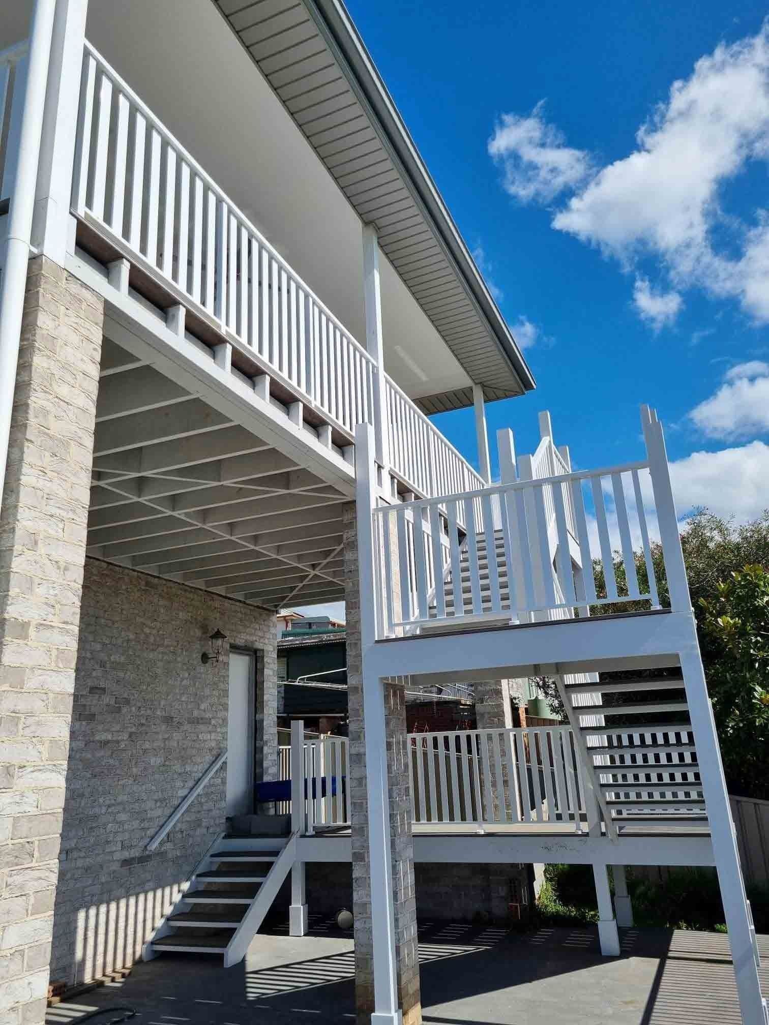 A House With a Balcony and Stairs on the Side of It — D & T Balustrade Systems In Unanderra, NSW