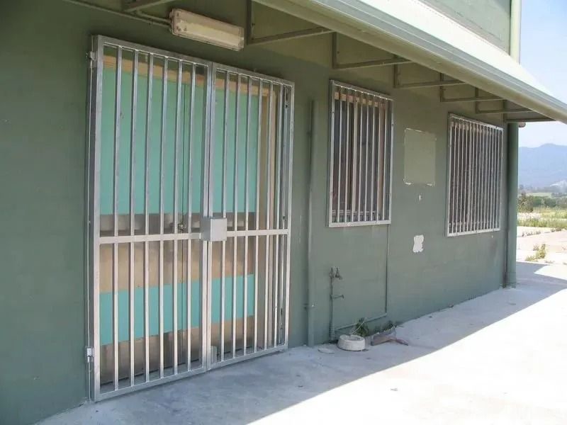 A Building With a Fence Around the Doors and Windows — D & T Balustrade Systems In Unanderra, NSW