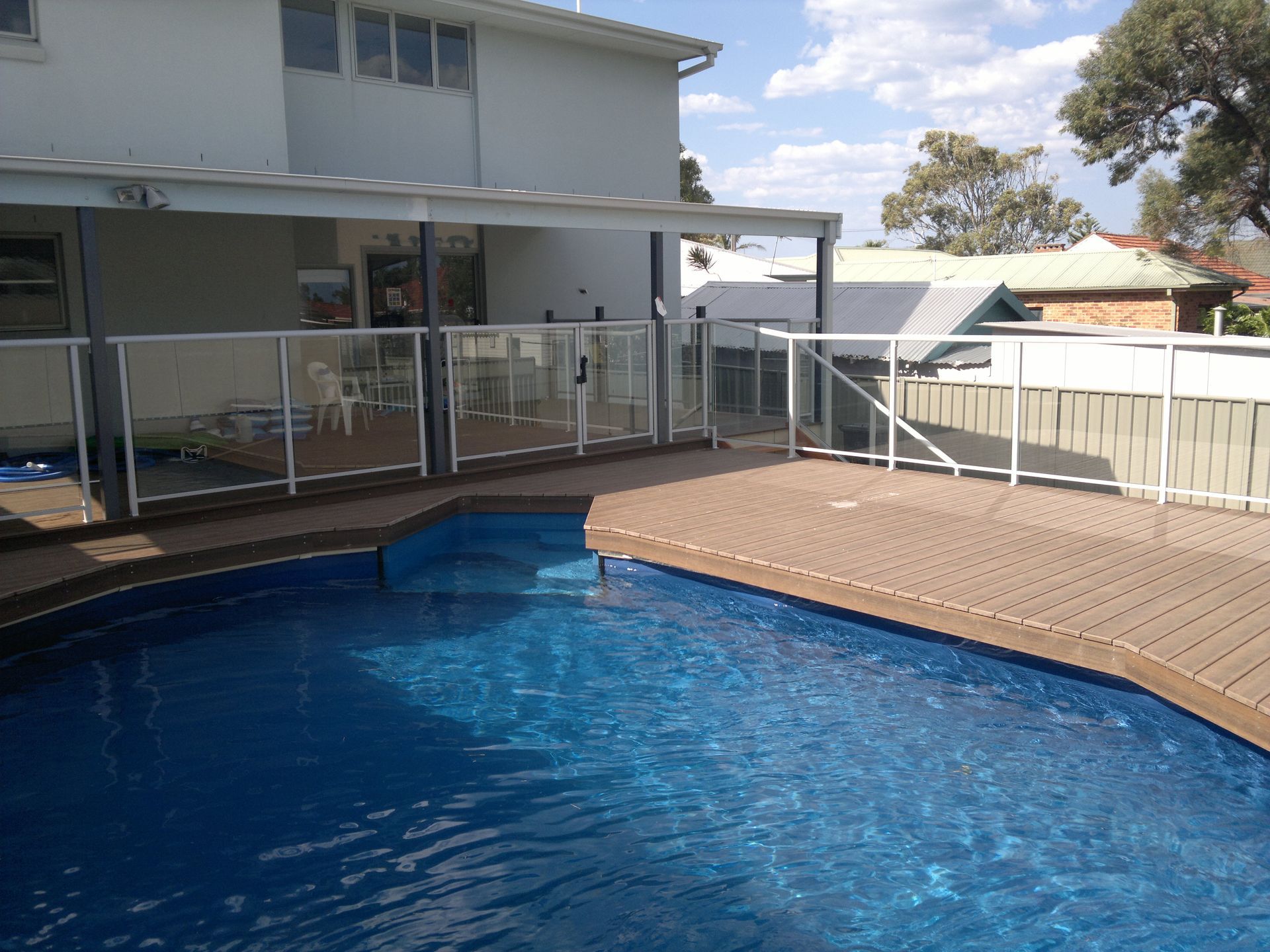 A White House With a Swimming Pool in the Backyard — D & T Balustrade Systems In Shellharbour, NSW
