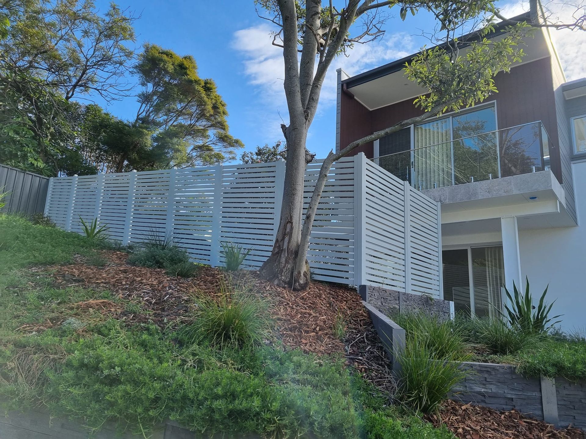 White slatted fence next to a modern house — D & T Balustrade Systems In Unanderra, NSW