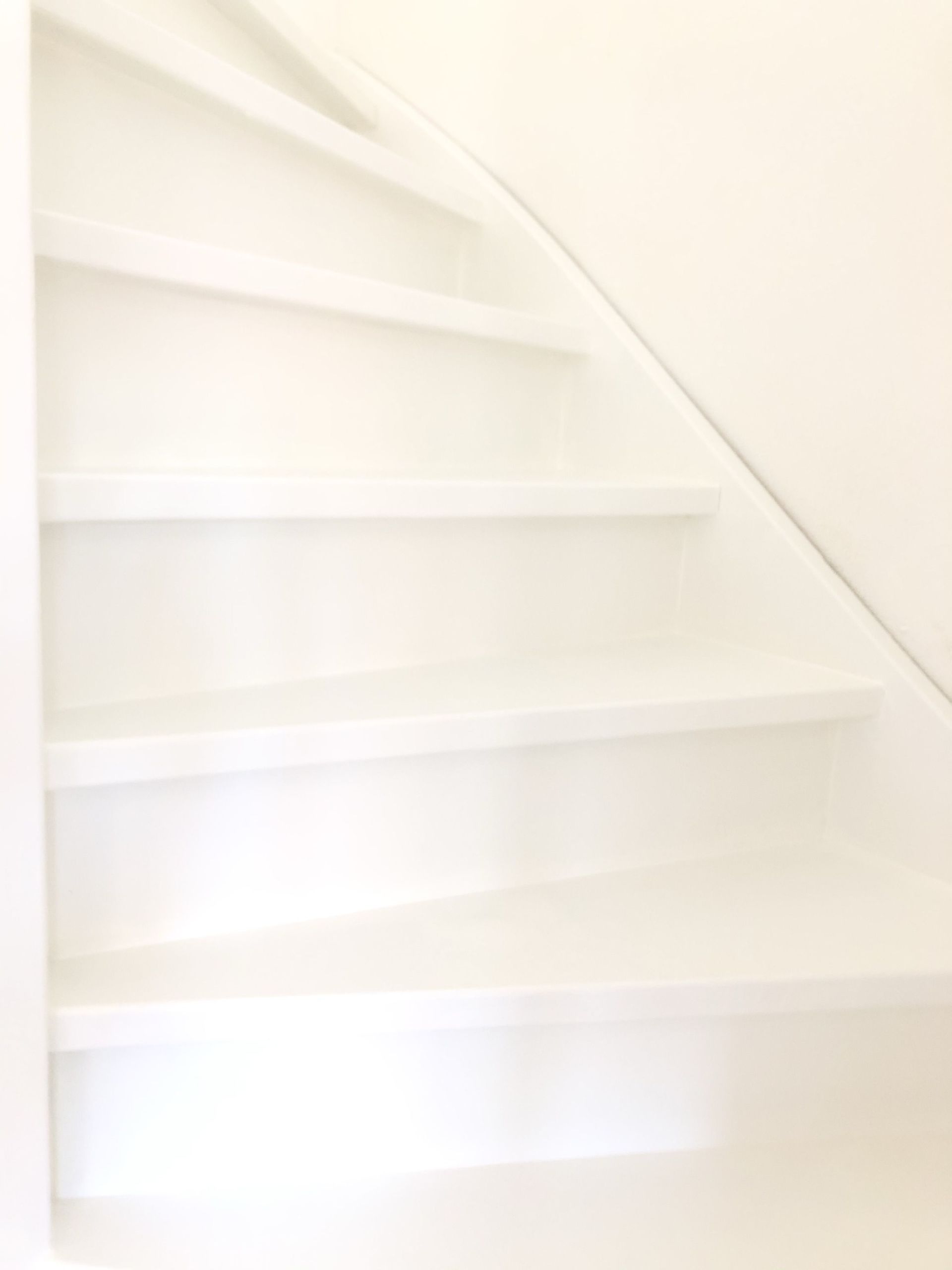 Wit geschilderde houten trap.