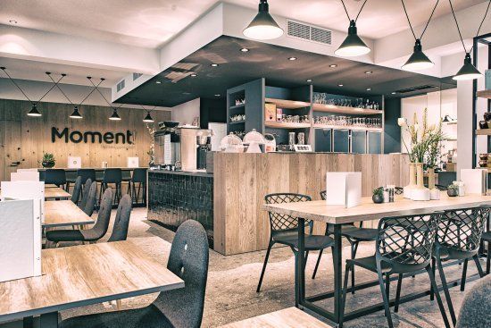 Een restaurant met tafels en stoelen en een bordje met de tekst moment.
