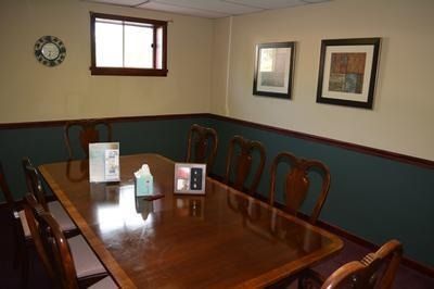 The front door of a house with a porch and plants in front of it.