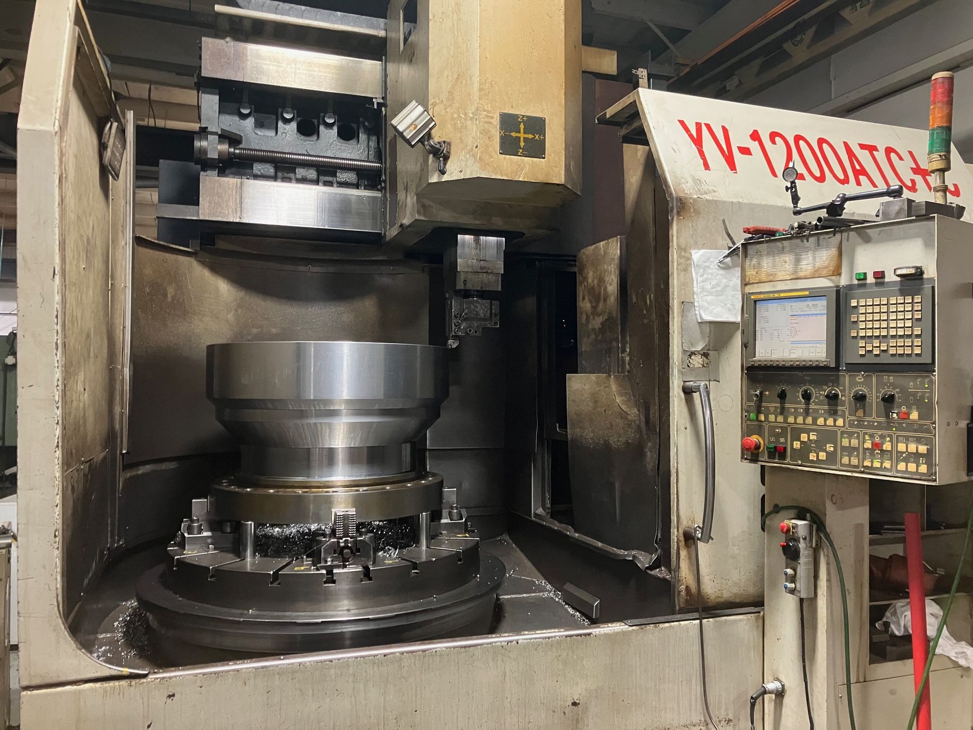 A machine is sitting in a room with a large metal object on it.