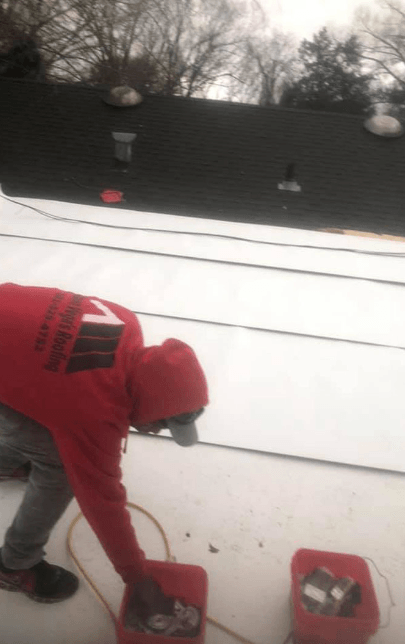 man working on half-finished roof