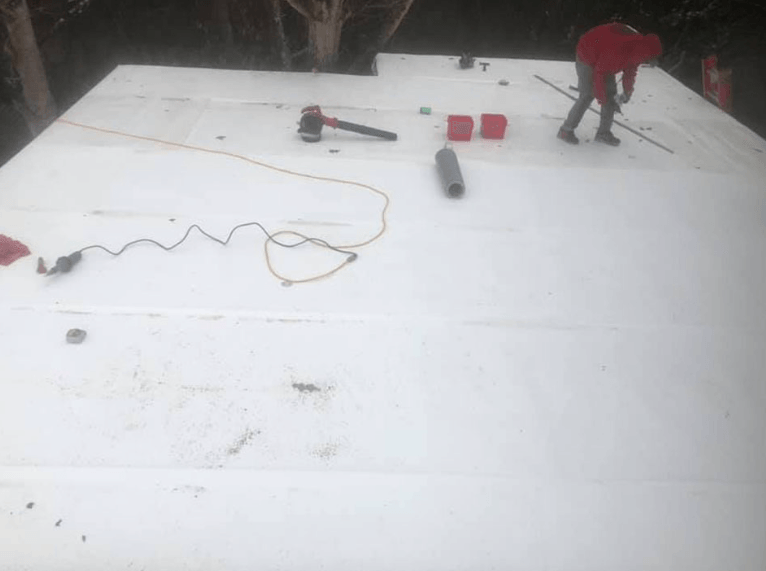 contractor with many roofing tools on roof