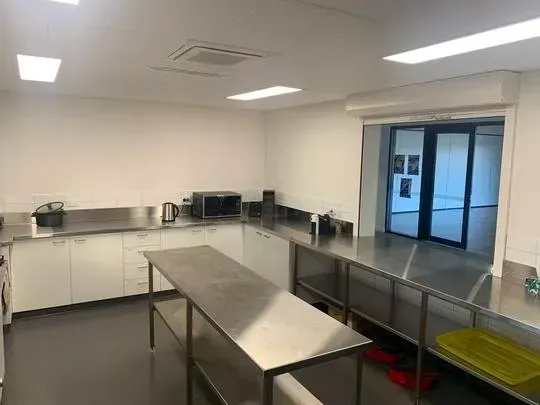 Modern kitchen with stainless steel appliances, white cabinets, and a prep island.