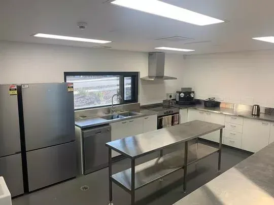 Modern kitchen with stainless steel appliances, white cabinets, and a prep island.