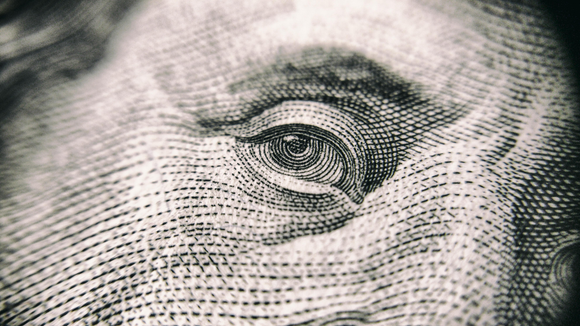 A close up of the eye of a dollar bill.