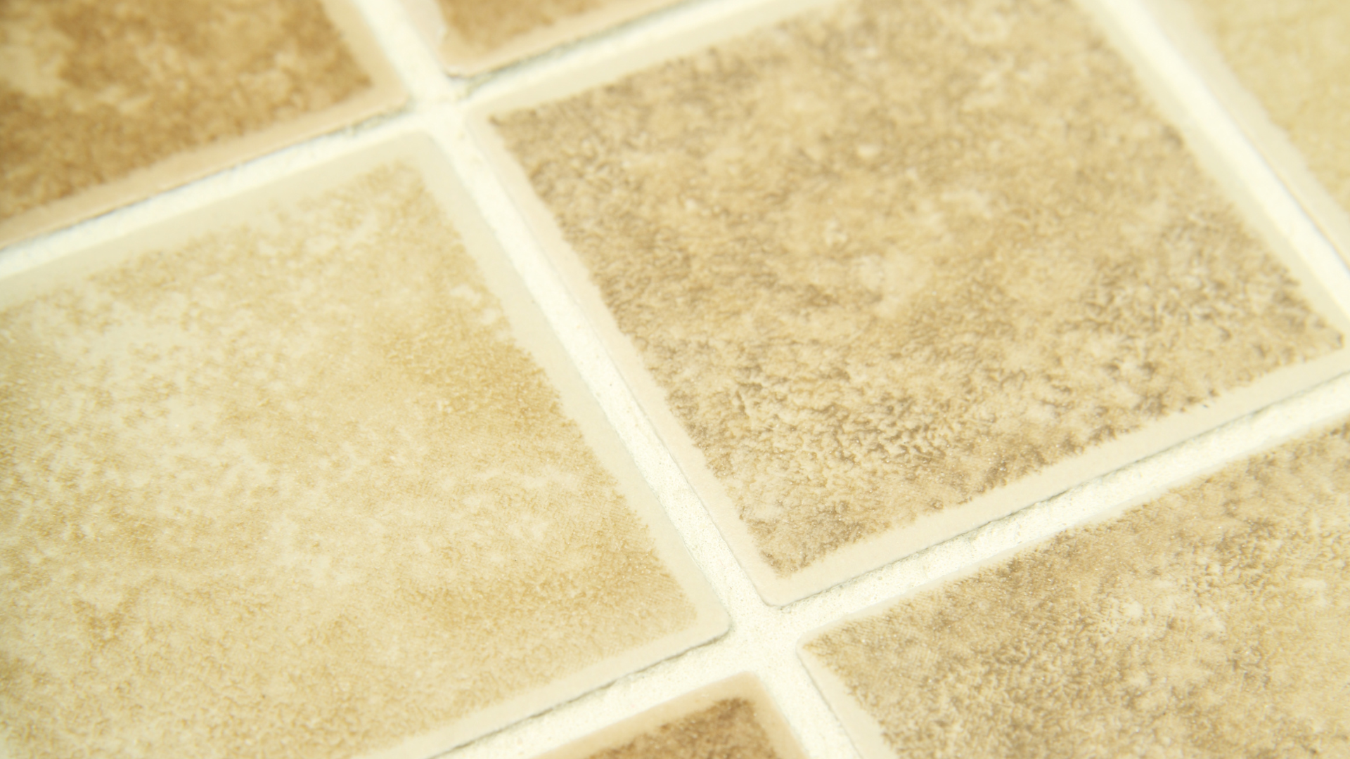 A close up of a tile floor with white grout.