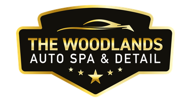 Logo for The Woodlands Auto Spa & Detail, black and gold shield, car silhouette, text, stars.