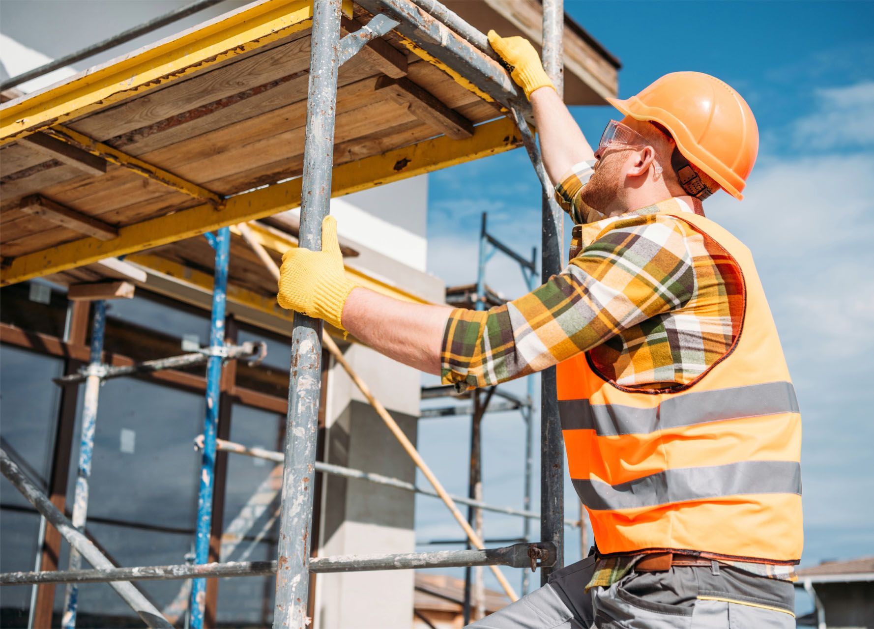 A construction worker is working on a scaffolding at a construction site.