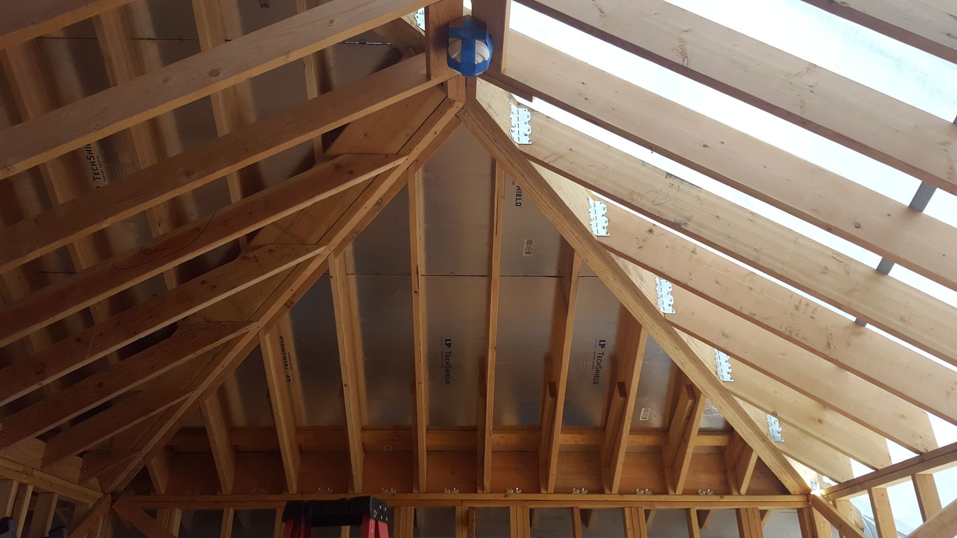 The ceiling of a building under construction is made of wood.