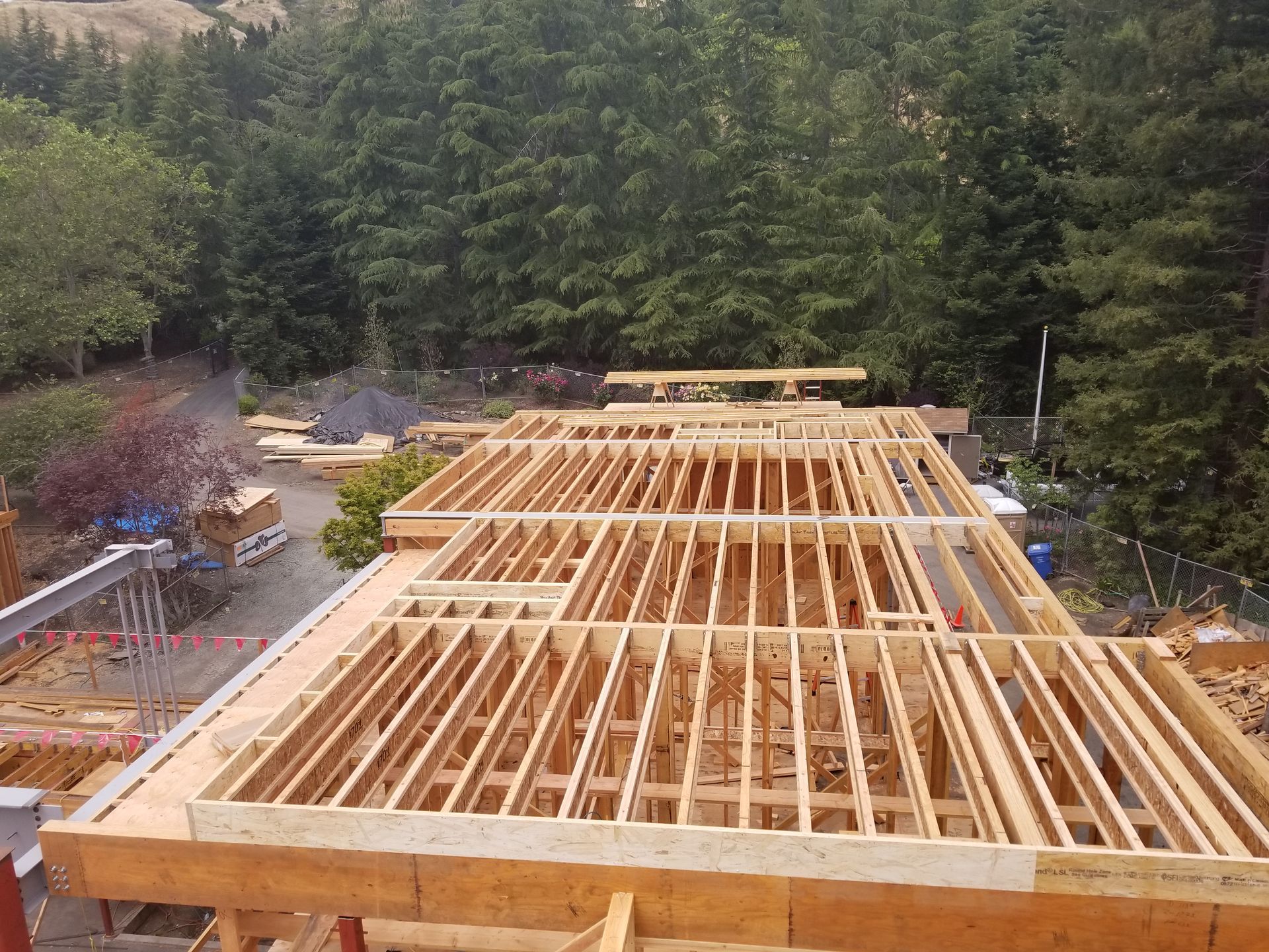 A large wooden structure under construction with trees in the background