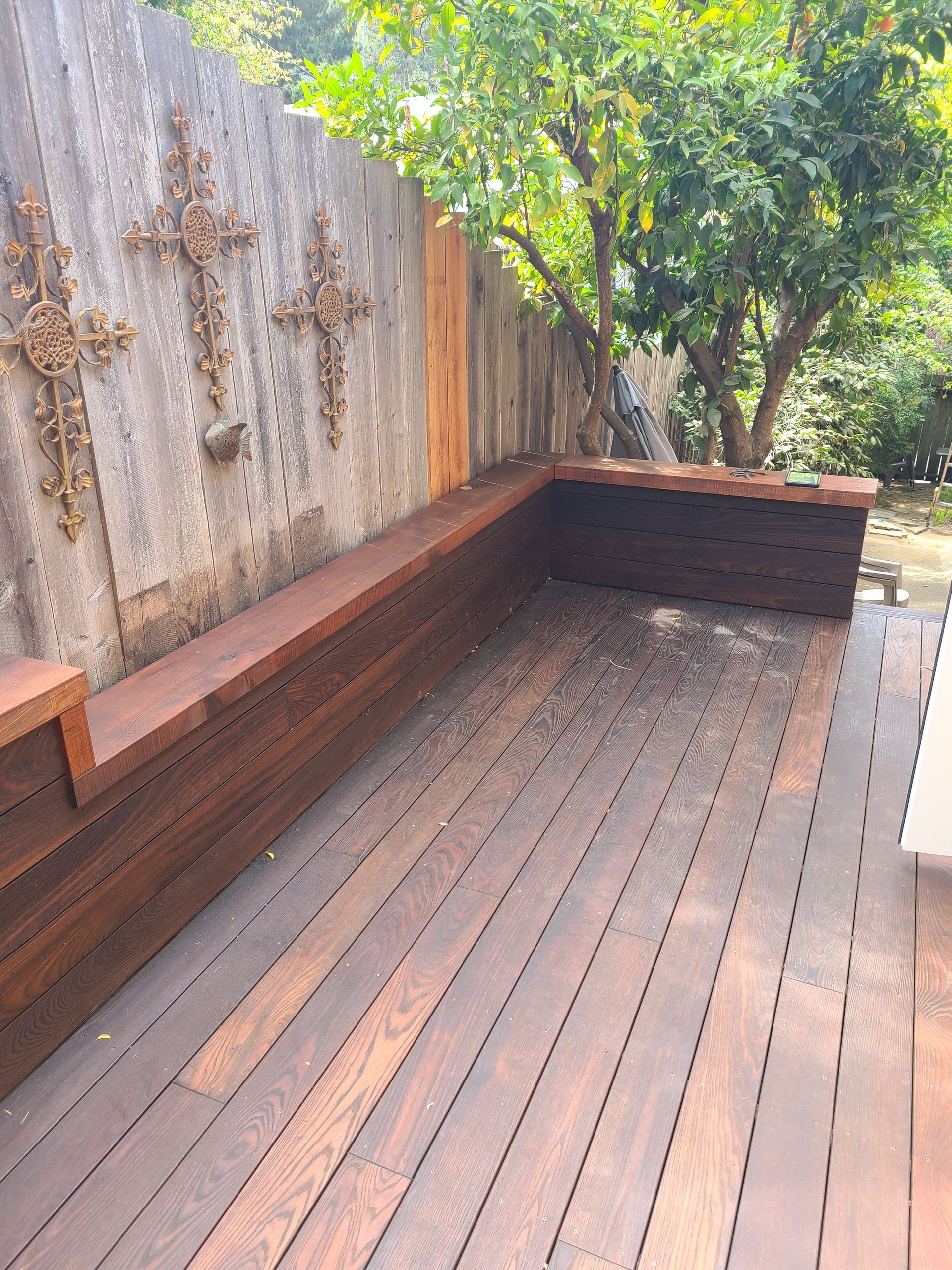 A wooden deck with a railing and trees in the background