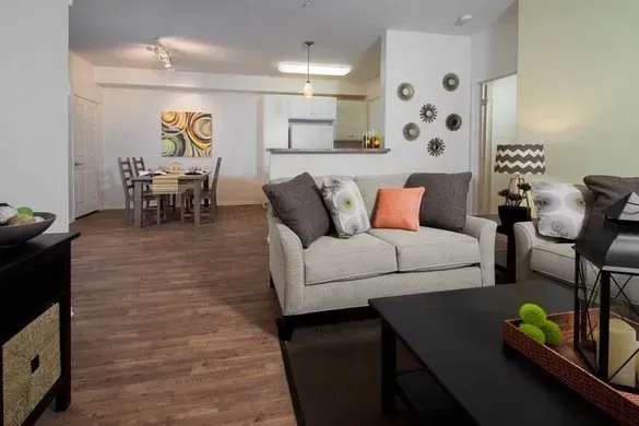 photo of a living room with a dining area and kitchen in the background