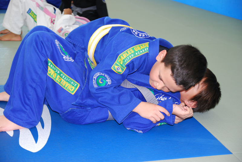 A group of children in karate uniforms are posing for a picture.