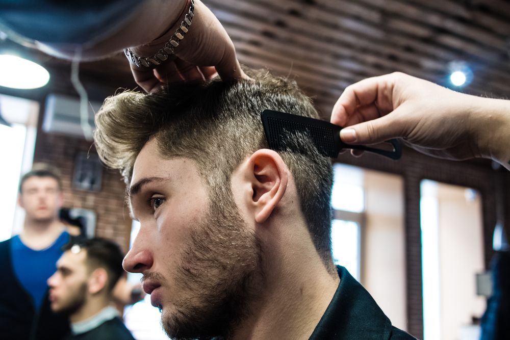 A Man is Getting His Hair Cut by a Barber in a Barber Shop — Barbarella Hair in Maryborough, QLD