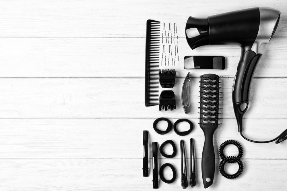 A Black and White Photo of a Hair Dryer, Combs, Scissors and Brushes — Barbarella Hair in Maryborough, QLD