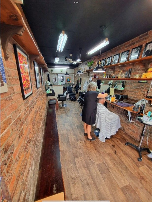 A Woman is Getting Her Hair Cut in a Barber Shop — Barbarella Hair in Maryborough, QLD