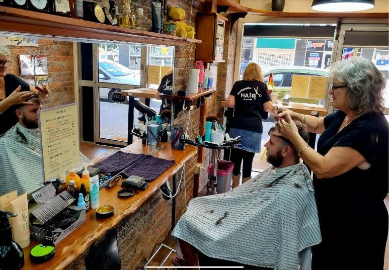 A Woman is Cutting a Man's Hair in a Barber Shop — Barbarella Hair in Maryborough, QLD