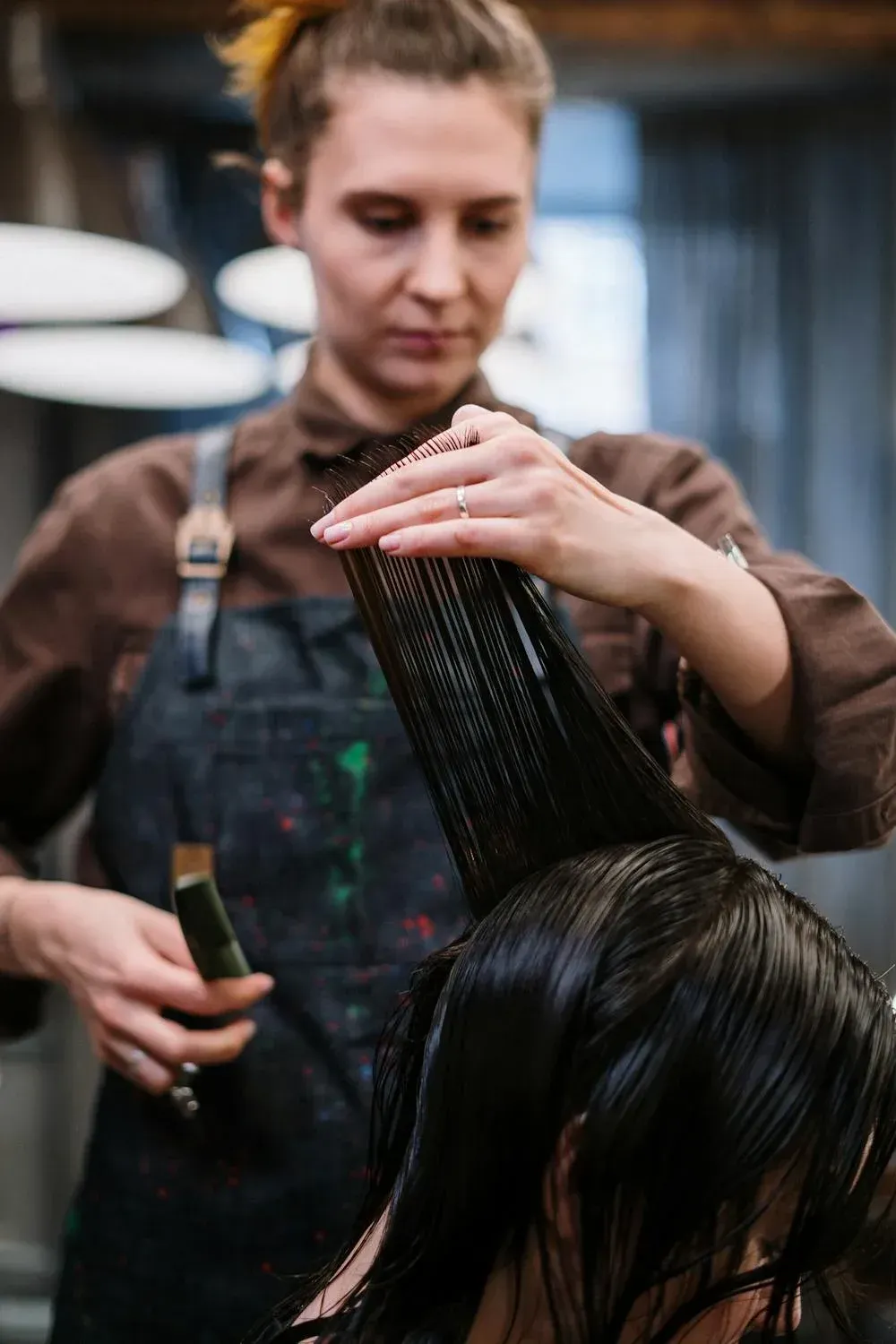 A woman is getting her hair cut by a hairdresser in a salon. — Barbarella Hair in Maryborough, QLD