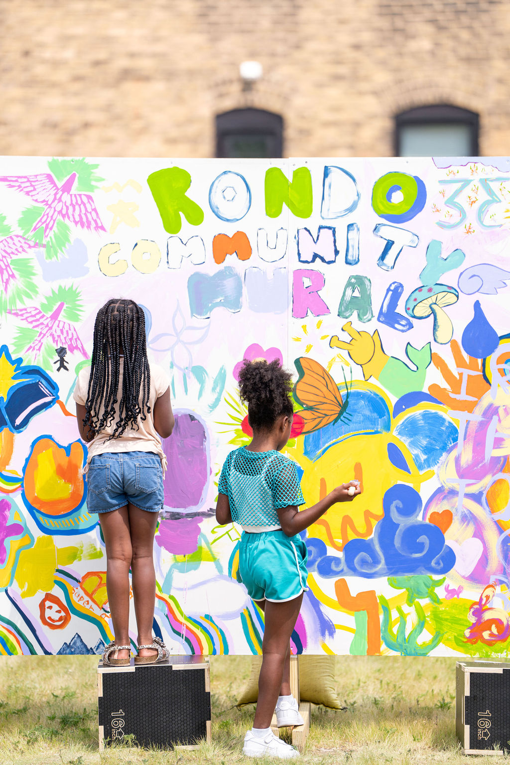 Two people paint a colorful 