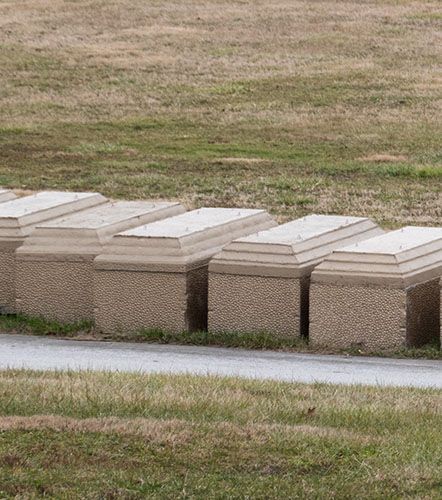 Silver casket adorned with a large arrangement of red roses.