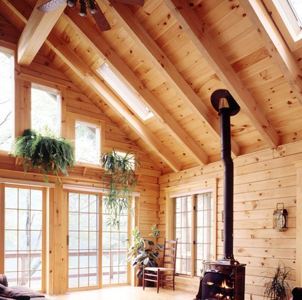A living room with lots of windows and a wood stove