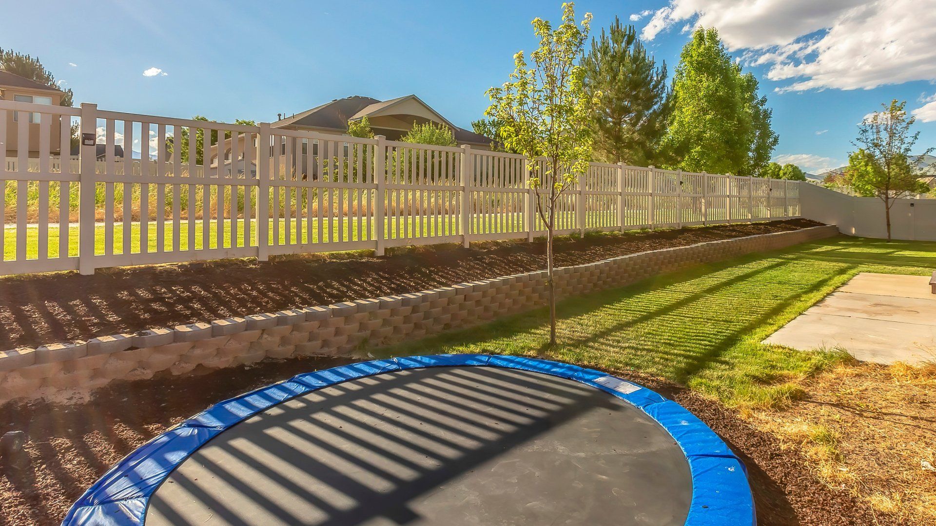 A sunken trampoline nestled in a vibrant, well-manicured garden.