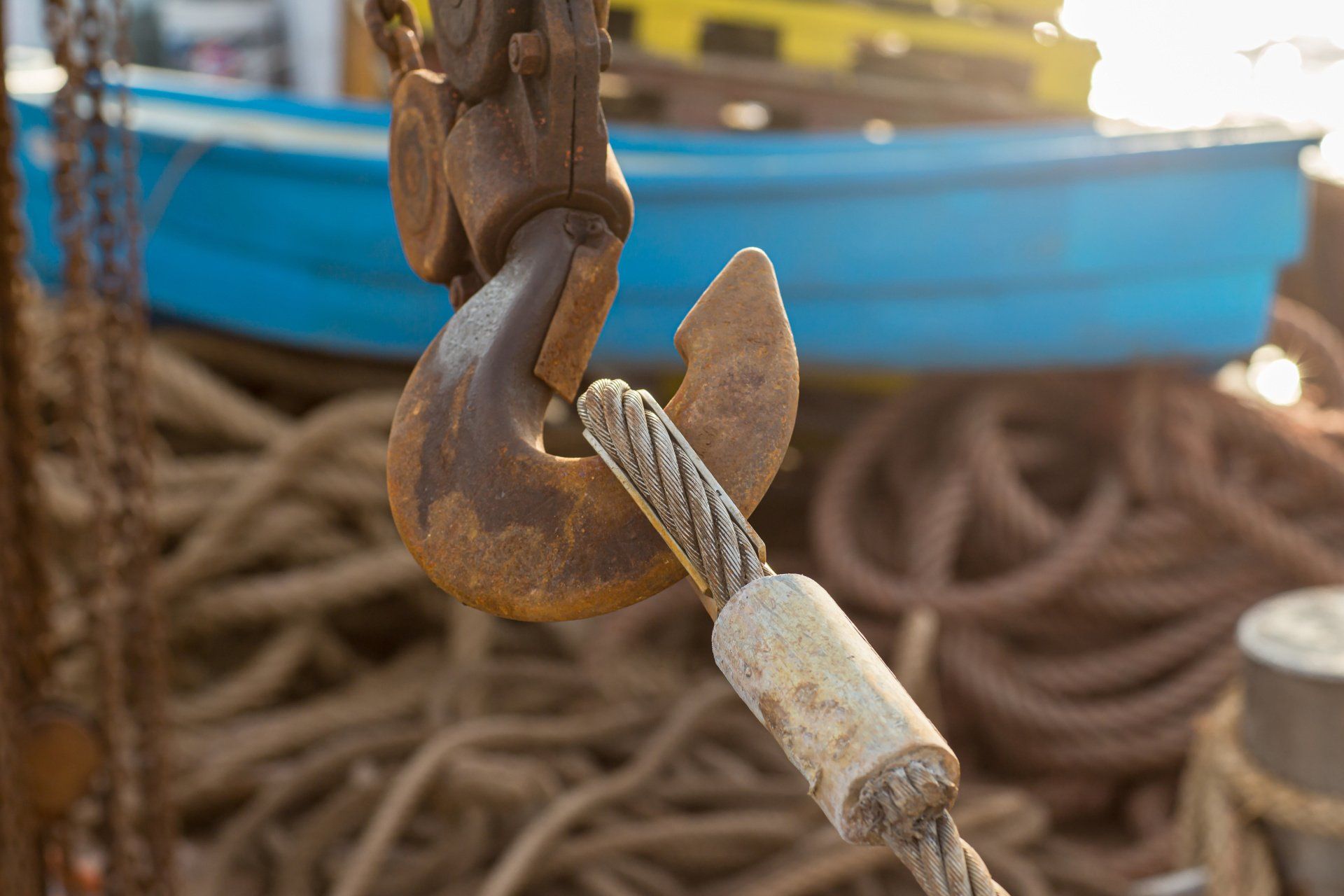 Crane hook with a coiled rope attached, ready for heavy lifting.