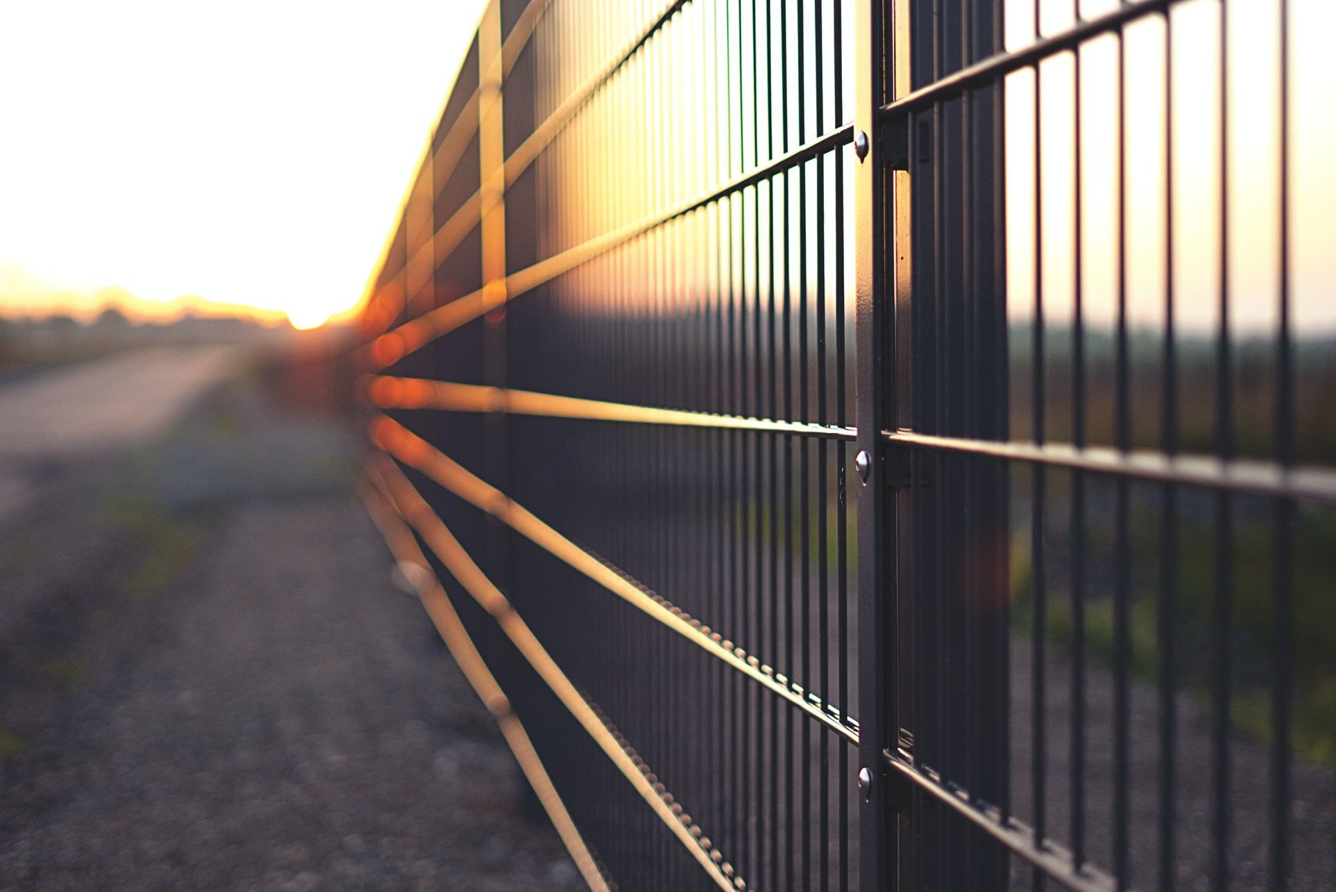 Vertical lines of a sleek black metal fence, creating a modern and minimalist design.