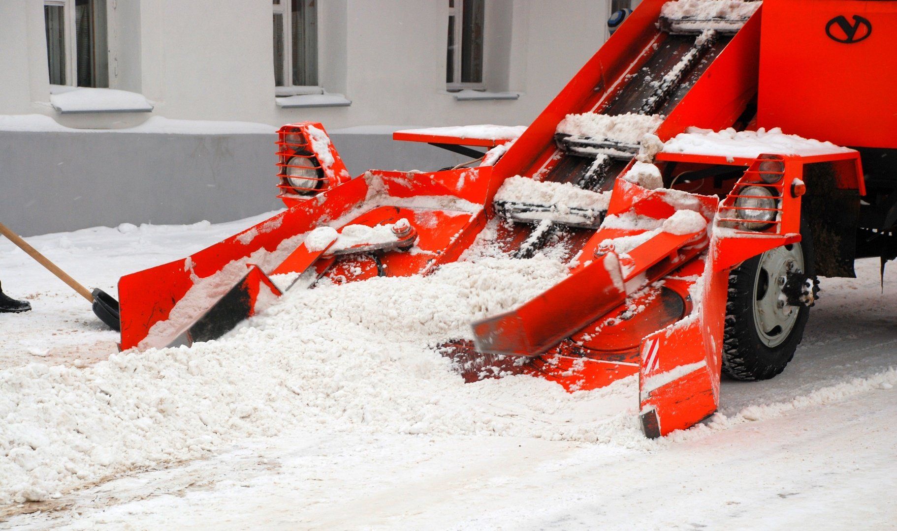Snow plowing in action, clearing a path through a snow-covered road with a powerful snowplow truck.