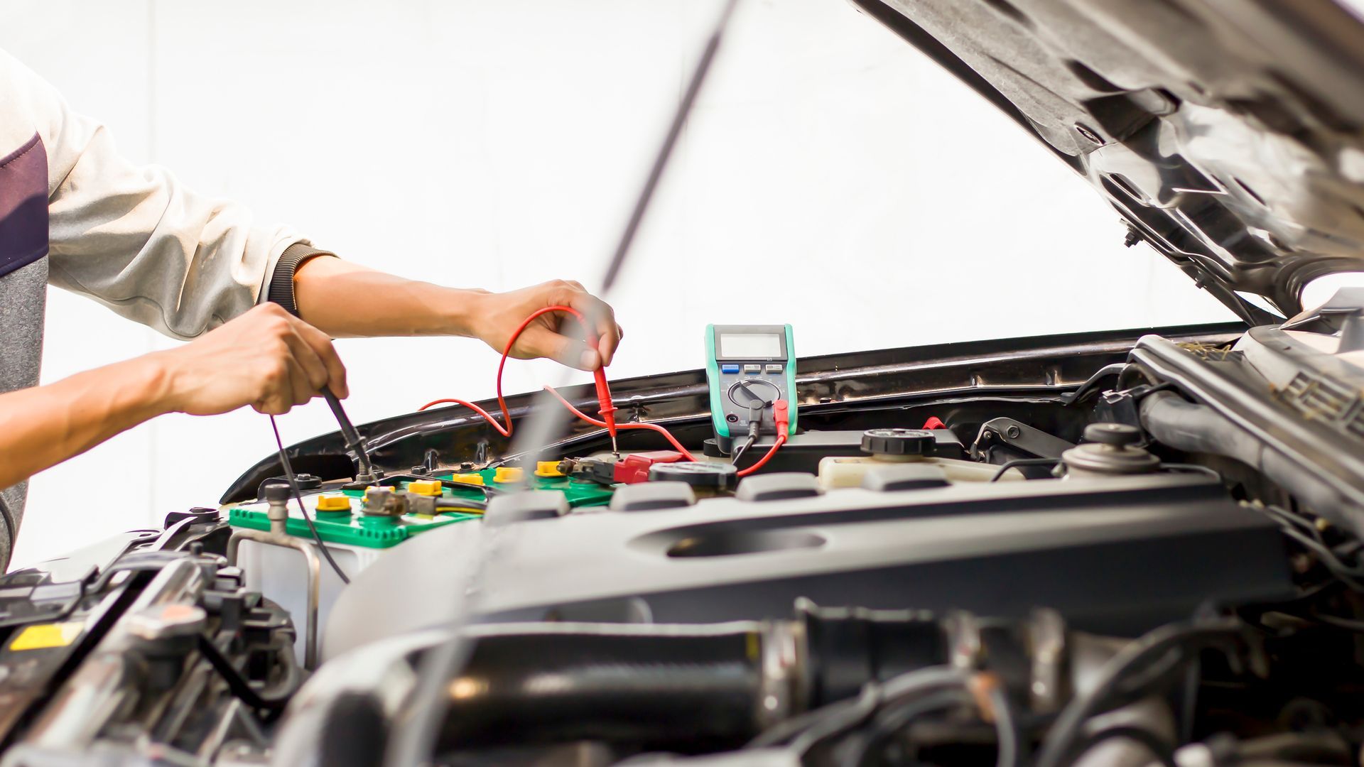 A man is working on the engine of a car.