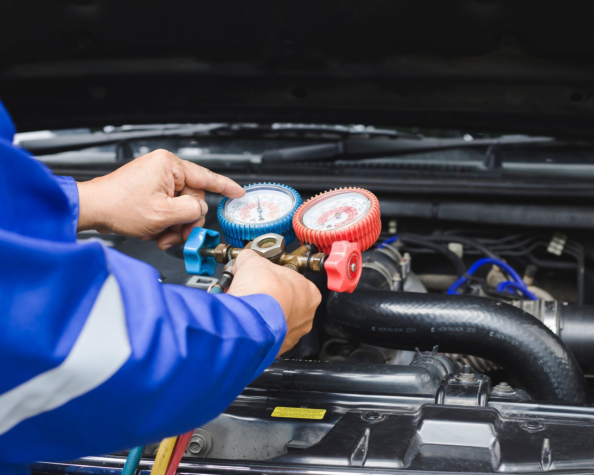 A man is working on the engine of a car.