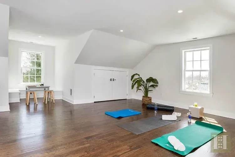 A room with a lot of windows and a yoga mat on the floor