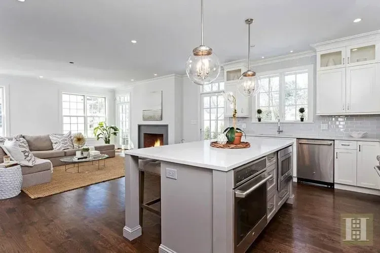 A kitchen with a large island in the middle of it and stainless steel appliances.