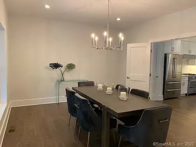 A dining room with a table and chairs and a chandelier.