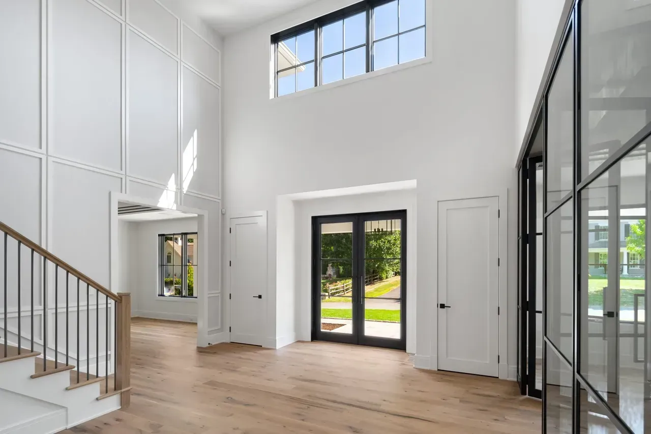 A large empty room with a staircase and a lot of windows.