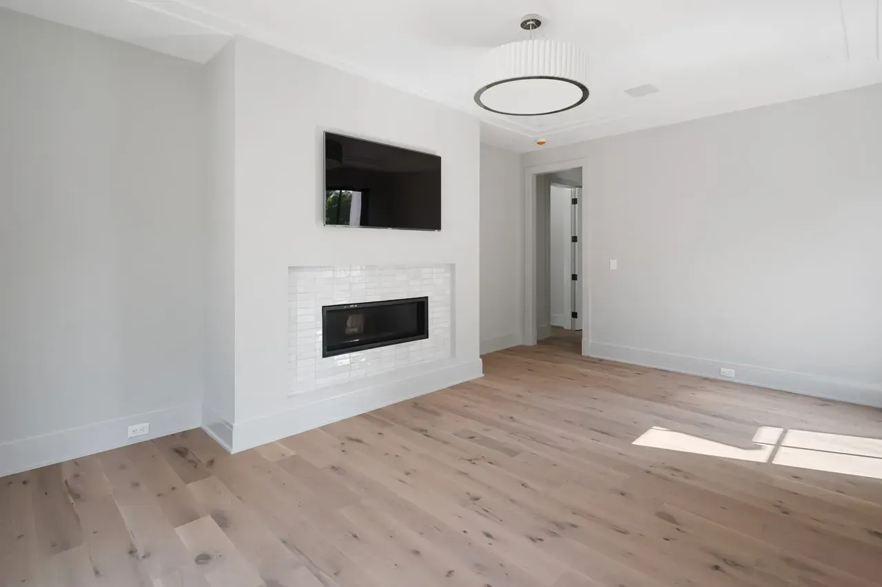 A living room with a fireplace and a flat screen tv on the wall.