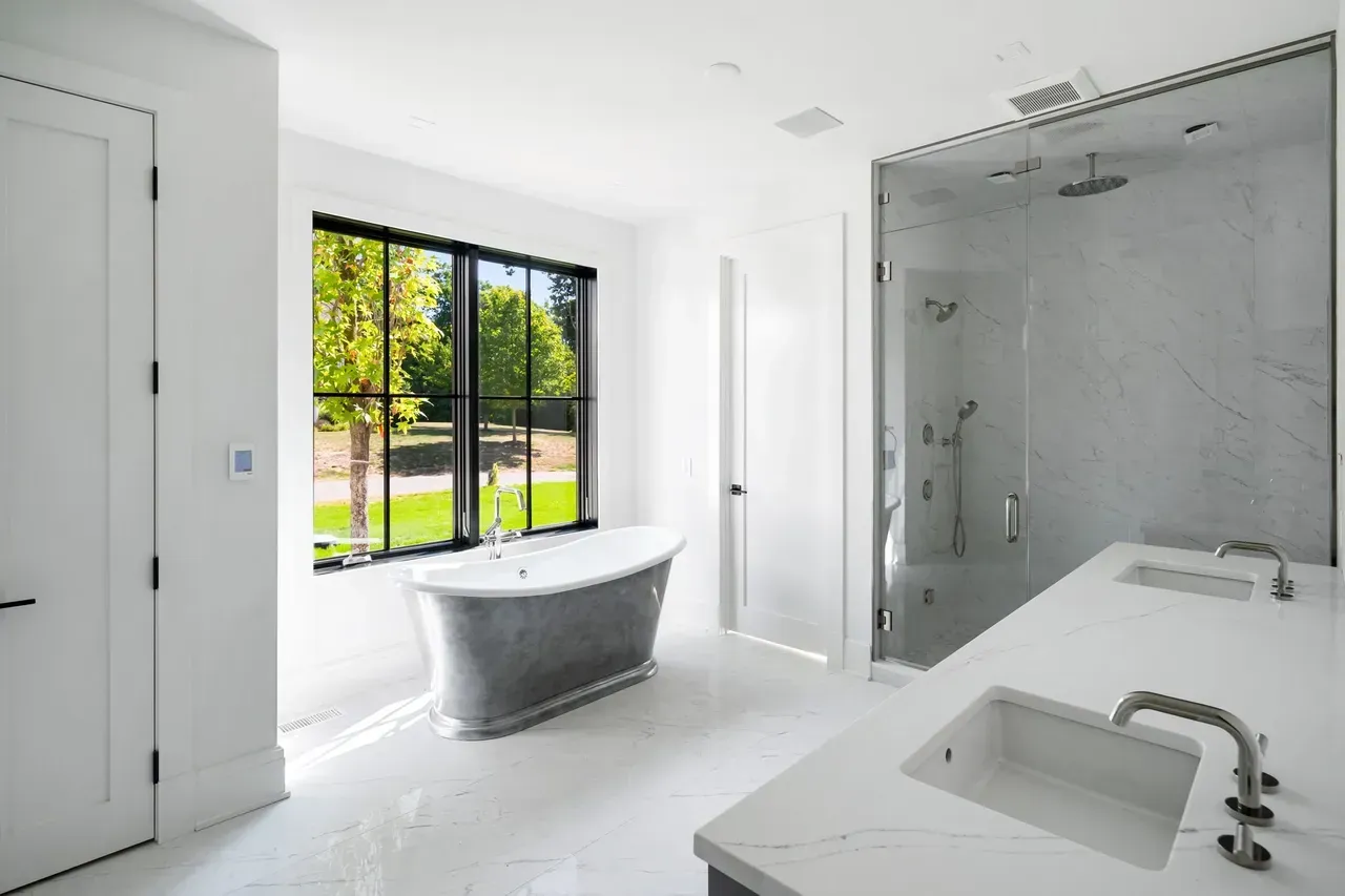 A bathroom with a tub , sink , and shower.