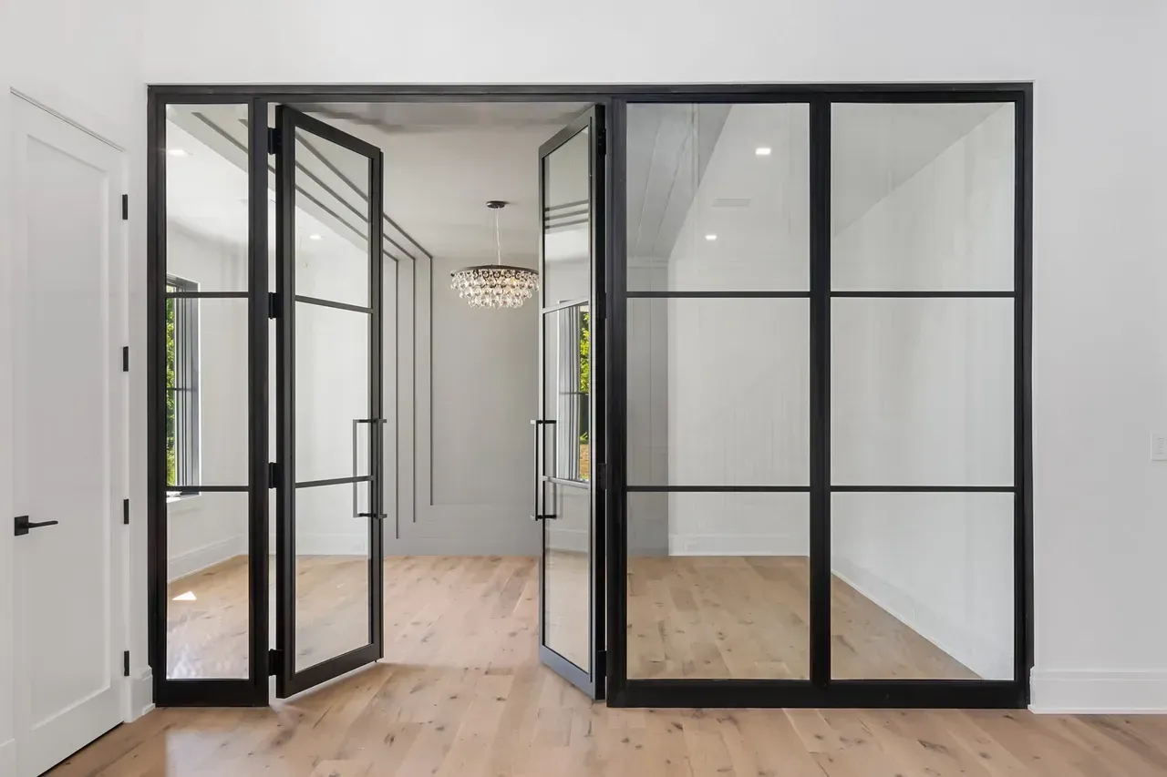 A room with a lot of glass doors and a chandelier.