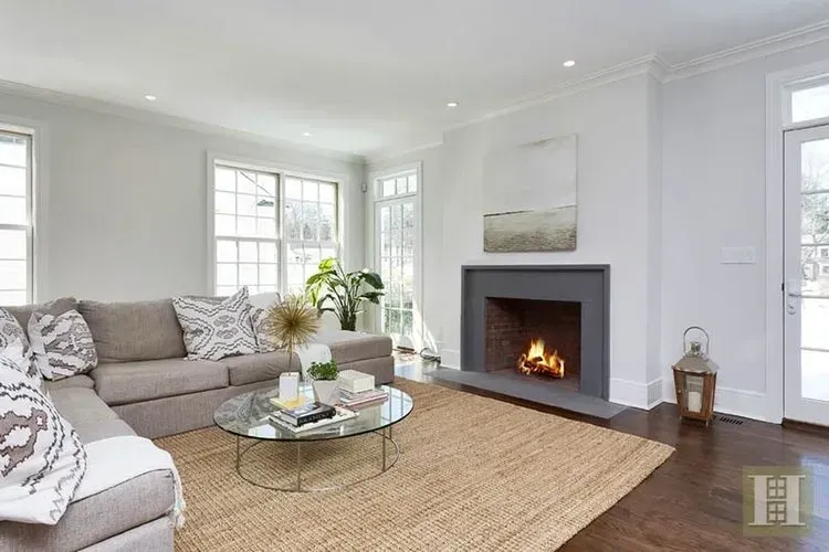A living room with a fireplace , couch , coffee table and rug.