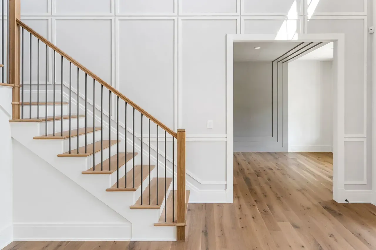 A staircase with wooden steps and a metal railing in a house.